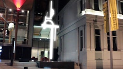 A digitally rendered abstract sculpture lights up outside an art gallery.