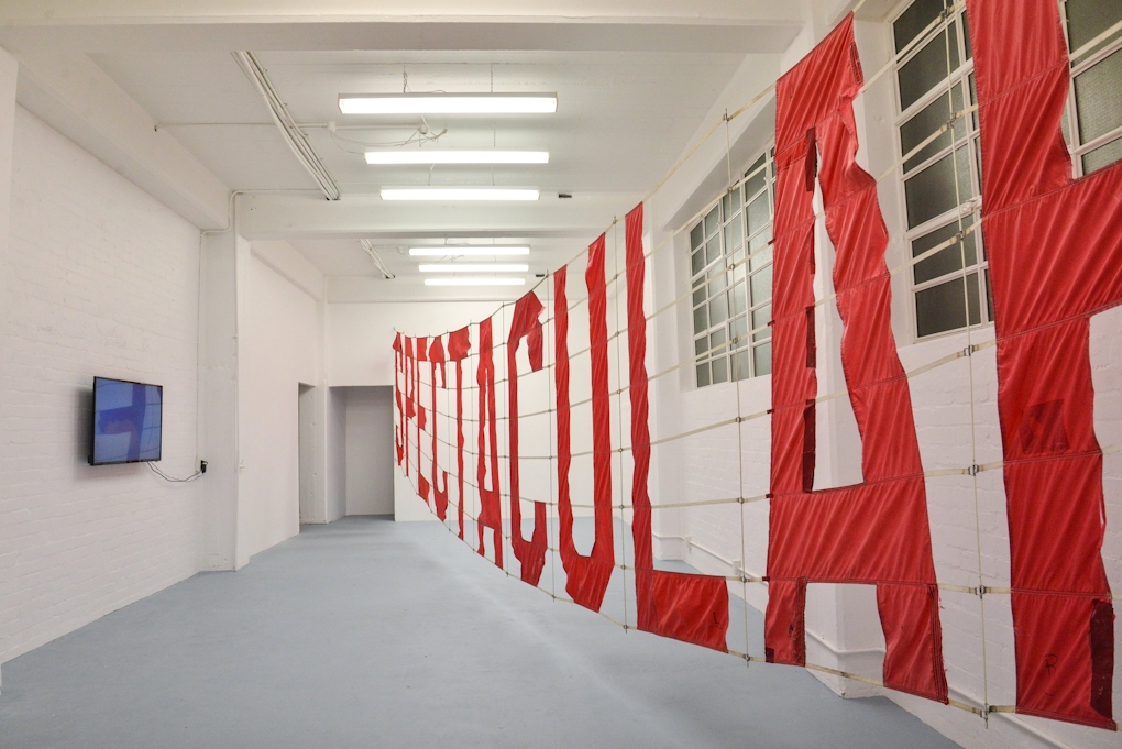 A large red banner with the word SPECTACULAR on it fills the gallery from wall to wall