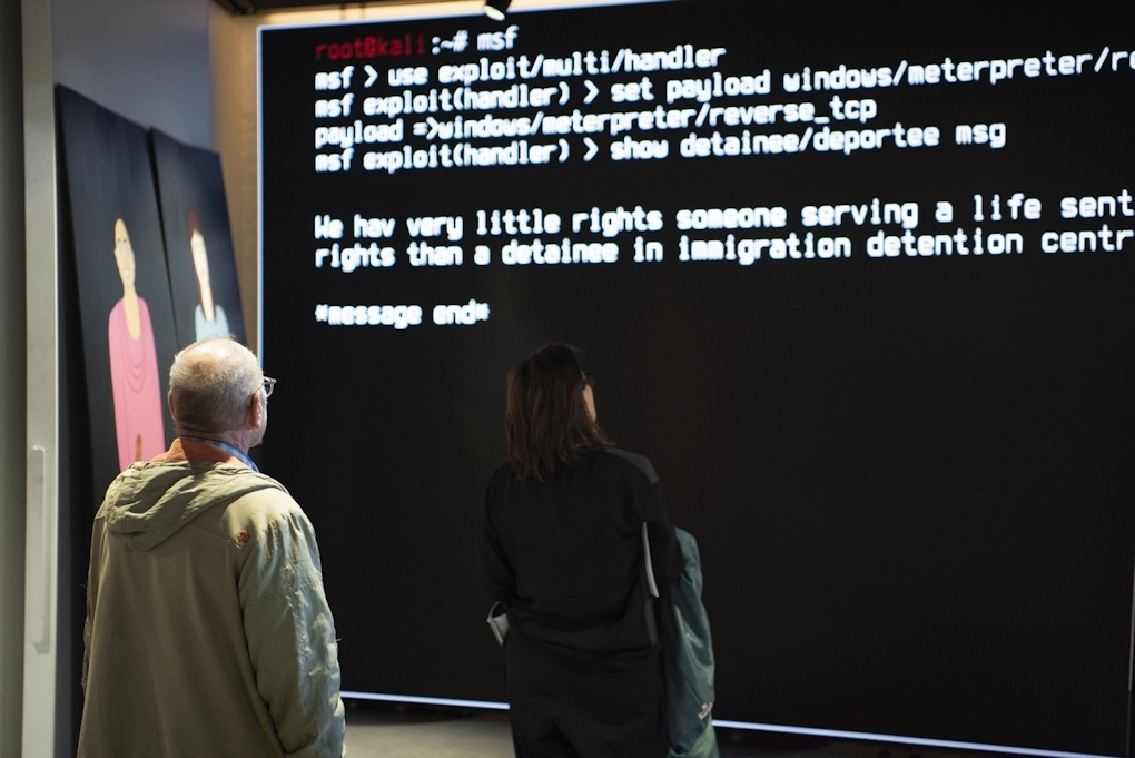 People stand in front of a large screen of text messages being received