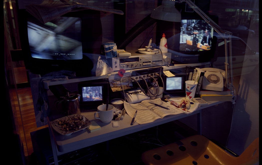 A desk with multiple screens showing surveillance footage