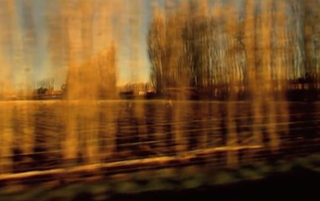 An image taken from a moving vehicle shows golden fields blurring by