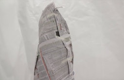 The artist does a performance with newspaper wrapped around their body, no sign of a body is left.
