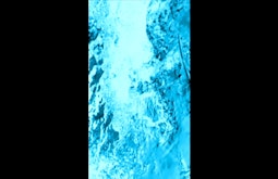 Water in a stream flows by, the image is all neon blue.