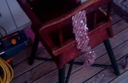 A view down onto a child's high-chair with a silver and red plastic ribbon on it.