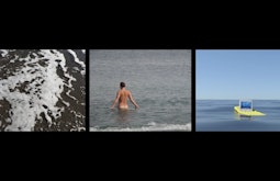 Three films side by side. The first of a shallow wave. The second of a person wading naked into the water. The third of a digital sea with a computer floating in the water.
