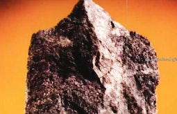 A close-up of a rock with a bright orange background.