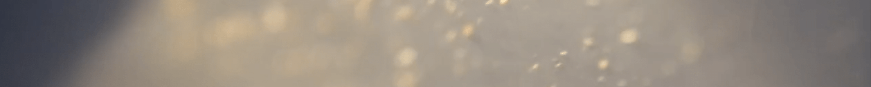 An abstract image of light yellow dust particles or microbes on a light grey hue