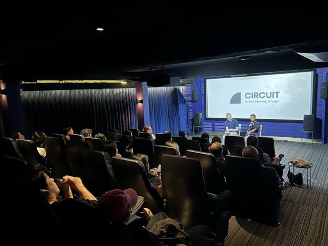 Two people in a cinema answer questions from an audience. On the screen reads the word CIRCUIT.