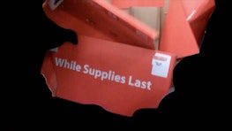 A ripped and torn product box floats in black space, on the side text reads 'While Supplies Last'
