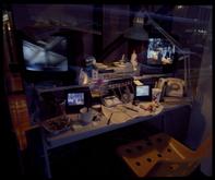 A desk with multiple screens showing surveillance footage