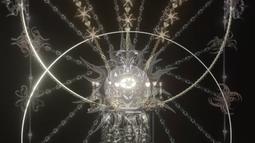 A digital sculpture of two intersecting rings adorned with chains and golden flames.