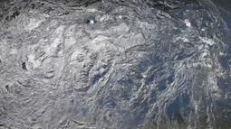 The surface of a large body of water bubbles and ripples.