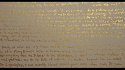 A wall with text written in gold paint.