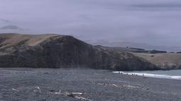 Coastal cliffs and hills on a cloudy grey day.
