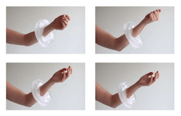A heavy thick bracelet made of ice is worn on someones arm as they gently clasp and unclasp a fist