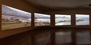 A four channel video installation in a darkened gallery showing a landscape