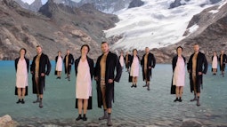On a lake at the bottom of a glacier 2 people in pyjamas are superimposed repeatedly, as if they're standing on water.