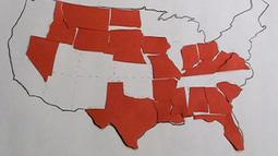 An outline map of the USA is partially filled in with red paper cut outs of some US States.