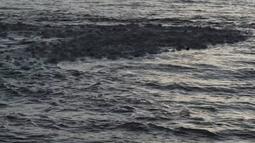 Sea foam gathers in the movement of small waves.