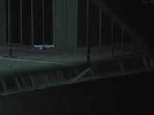 A dim light shines on metal guard rails.