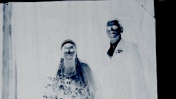An image negative of two people dressed in formal attire.