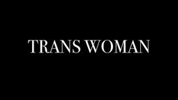 The tex 'TRANS WOMAN' is written in white across a black background.