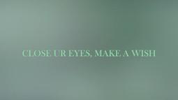 A blurry screen of leaf green has the text 'Close ur eyes, make a wish' written overtop.