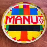 A group of cuisenaire rods show a bright TV test pattern and the words MANU TV