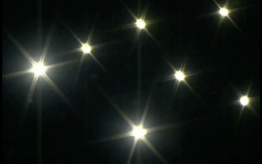 7 bright lights create star shapes in the dark sky