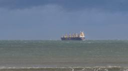 A container ship rests on choppy waters.