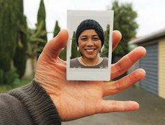 A hand holds a Polaroid of Janet Lilo smiling