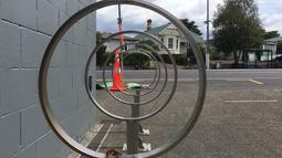 Circular bike stands are lined up to create a tunnel view.