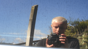 Jo Bragg photographs their self reflection in a car window