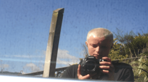 Jo Bragg photographs their self reflection in a car window