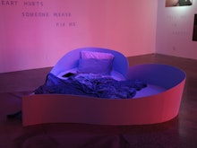 A heart shaped bed lies in the centre of the gallery. The gallery walls have poetry painted on them