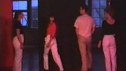 Four people walk around one another in choreographed movements.