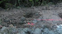 Turned over earth and rocks with a red spray-painted line running through.