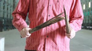 A man holding two sticks