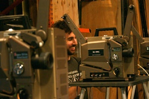 American filmmaker Roger Beebe setting up a 16mm expanded cinema presentation