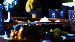A dinner table lit with bright blue and yellow light. Text reading, I'd probably agree with you, I'm like a dildo in a corner, is written onscreen.