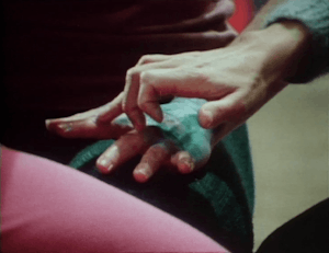 A hand covered with a wet bandage is caressed