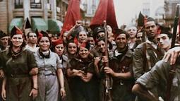 A crowd of soldiers holding guns and flags stand looking at the camera, their faces have been digitally imposed onto the bodies.