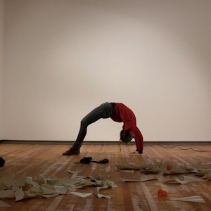 Melissa performs a bridge pose in a gallery