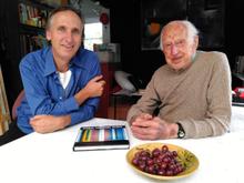 Mark Amery and Michael Nicholson sit at a kitchen table with a bowl of grapes near them