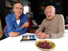 Mark Amery and Michael Nicholson sit at a kitchen table with a bowl of grapes near them