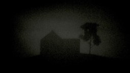 A silhouetted house and tree against a dark sky.