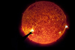 A silhouette of a hand pointing is shown against a clear image of the sun as a burning ball of gas