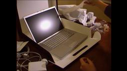 A mid 00's laptop is unboxed. The packaging materials are strewn on the table.