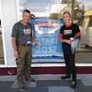 Tainui Stephens and Mark Amery standing by a Māoriland poster