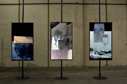 Three TVs are installed on poles which reach from ceiling to floor, displaying Sonya's video work